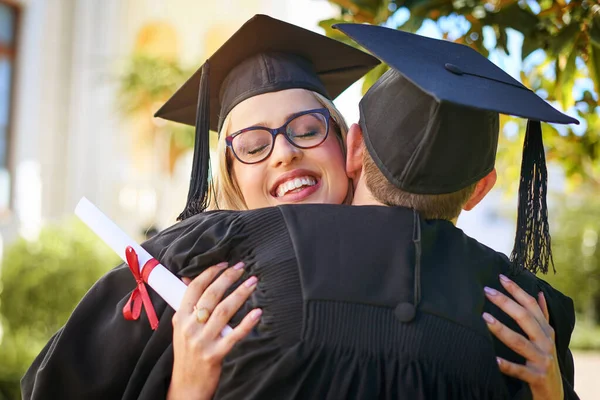 Wir feiern unsere große Errungenschaft. Aufnahme eines jungen Paares, das sich am Abschlusstag umarmt. — Stockfoto