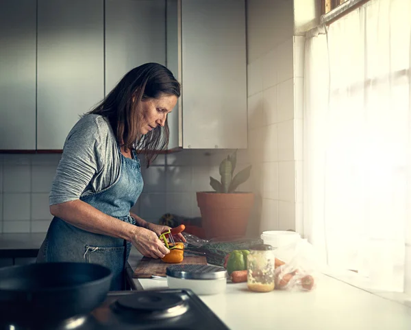 Ela é uma grande cozinheira caseira. Tiros de uma mulher madura preparando uma refeição em sua cozinha em casa. — Fotografia de Stock