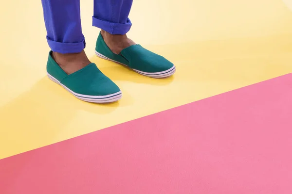 Färger och skor. Beskärda skott av skor på en färgglad bakgrund. — Stockfoto