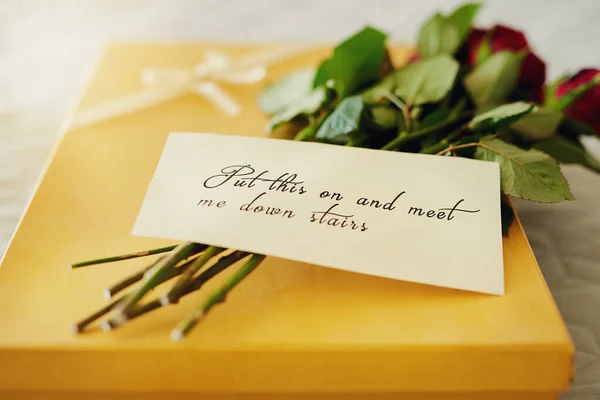Say I love you with a romantic surprise. Shot of a surprise gift and bouquet with a note attached to it. — Stock Photo, Image