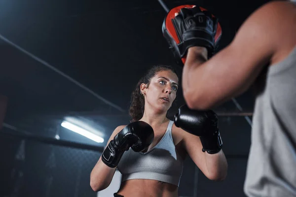 Laat je innerlijke beest los. Shot van een jonge vrouw oefenen met haar coach in een boksschool. — Stockfoto
