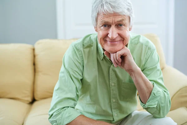 Llegaron los días felices. Retrato de un anciano feliz sentado en el sofá en casa. —  Fotos de Stock