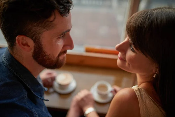 У них был момент. Снимок любящей молодой пары, любовно смотрящей друг другу в глаза, сидя в кафе во время свидания. — стоковое фото
