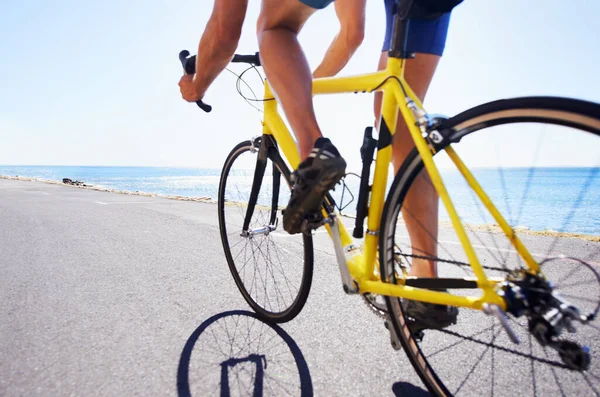 Beim Sport die Landschaft genießen. Ausgeschnittene Ansicht eines Radfahrers auf einer Meeresstraße. — Stockfoto