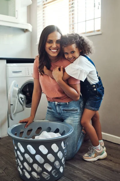 Gracias por todo lo que haces, mamá. Largura completa de una adorable joven abrazando a su madre mientras la ayuda con la lavandería en casa. —  Fotos de Stock