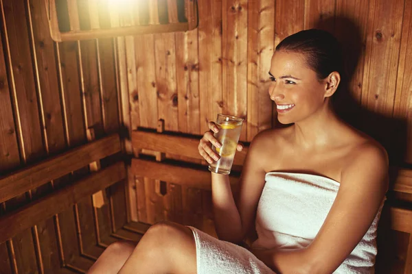 Genießen Sie ihre Sitzung mit der Sauna. Schnappschuss einer jungen Frau beim Entspannen in der Sauna eines Wellnessbereichs. — Stockfoto