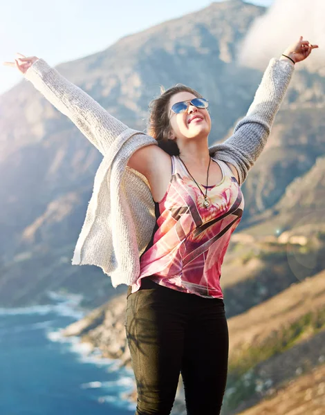 Feeling free in the great outdoors. Cropped shot of a teenage girl standing with her arms raised outdoors. Stock Image