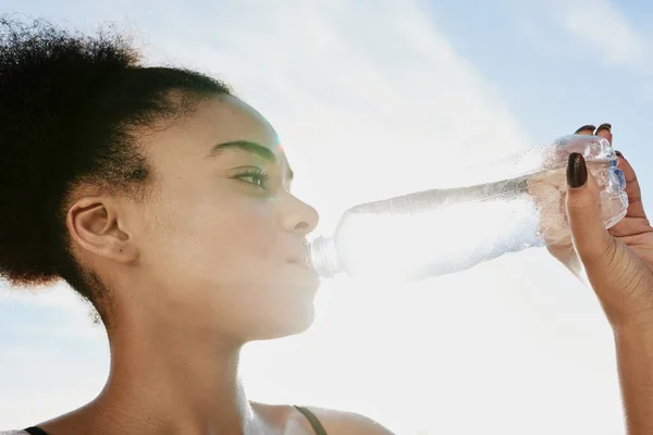 Taking an H2O timeout. Closeup shot of a sporty young woman drinking water after her workout. — Stock Photo, Image