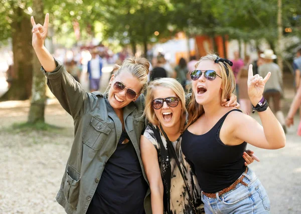 Ge den horn. Tre flickvänner festar på en musikfestival utomhus. — Stockfoto