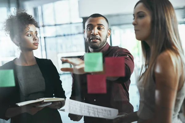 Att väcka projektet till liv med en brainstorming session. Skjuten av en grupp unga företagare brainstorming i ett modernt kontor. — Stockfoto