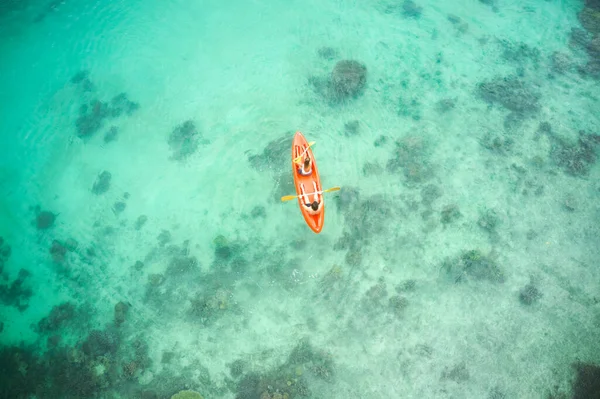 Love is an adventure, enjoy it. High angle shot of an adventurous young couple canoeing together in the beautiful oceans of Indonesia. — Stock Photo, Image