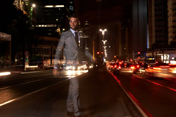 No has visto una ciudad hasta que la has visto a pie. Un hombre de negocios transparente caminando por una concurrida calle de la ciudad por la noche. — Foto de Stock