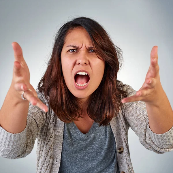 Wie konnten Sie das tun? Porträt einer wütenden jungen Frau, die vor grauem Hintergrund schreit. — Stockfoto