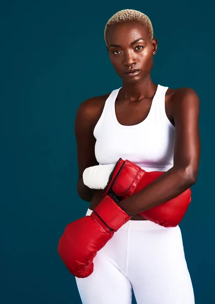Empurre-se para os seus limites. Retrato recortado de uma jovem boxeadora atraente de pé com suas luvas de boxe contra um fundo escuro. — Fotografia de Stock