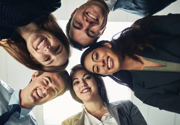 The best collaborate with the best. Low angle shot of a group of young businesspeople huddled together in solidarity. — Stock Photo, Image