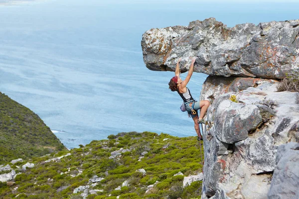 Manter um aperto forte. Uma jovem mulher balançando subindo pelo lado de uma montanha. — Fotografia de Stock