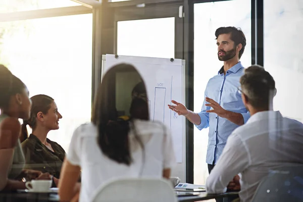 Das Unternehmen ins rechte Licht rücken. Aufnahme einer Gruppe von Männern bei einer Whiteboard-Präsentation vor Kollegen in einem Sitzungssaal. — Stockfoto