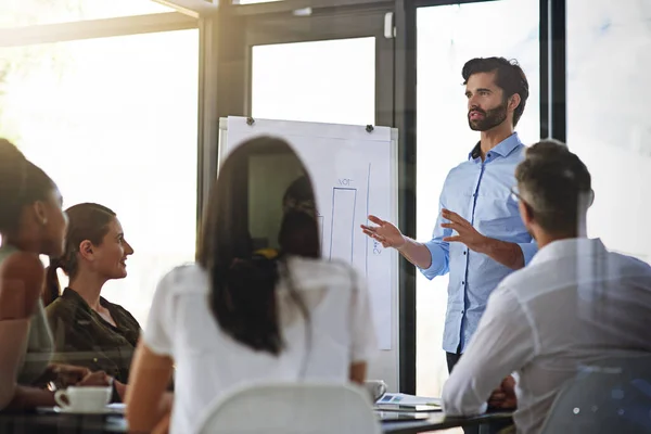 Mettere il business aziendale in prospettiva. Scatto di un gruppo di uomini che fa una presentazione della lavagna ai colleghi in una sala riunioni. — Foto Stock