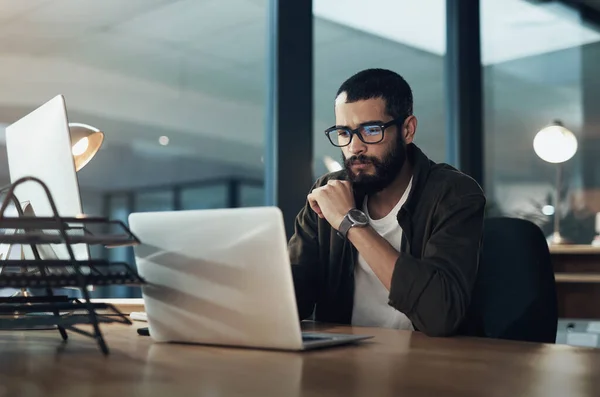 Quanto mais você se concentrar, mais rápido você encontrará a solução. Tiro de um jovem empresário usando um laptop durante uma noite em um escritório moderno. — Fotografia de Stock