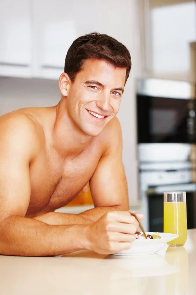 健康的な朝食で完璧な体を構築します。朝食を食べている筋肉質の男の作物のショット. — ストック写真