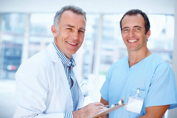 Doktor a rezident se usmívají. Portrét dvou mužů ve zdravotnictví. — Stock fotografie