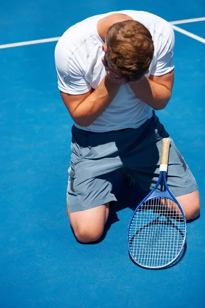 L'agonie de la défaite. Abattu d'un homme après avoir perdu un match de tennis. — Photo