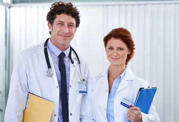 Happiness in the hospital. Cropped shot of two doctors looking happily at the camera. — Stock Photo, Image