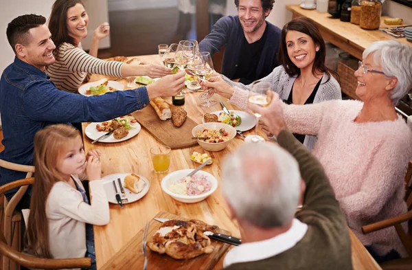 向家人敬酒一个家庭坐下来吃饭的剪影. — 图库照片