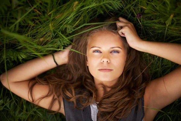 stock image Shes one with nature. Portrait of a gorgeous woman lying on her back outside.