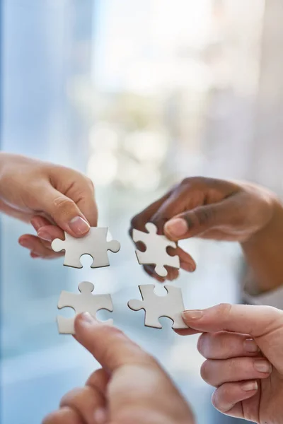 Samenwerken als een team. Handen die puzzelstukjes in elkaar zetten.. — Stockfoto