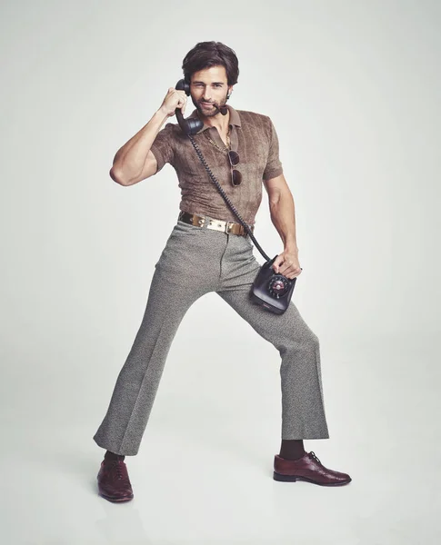 Haciendo todo con estilo. Un hombre guapo en un teléfono retro mientras posando. — Foto de Stock