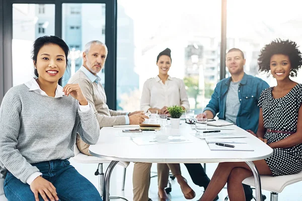 Todos son miembros invaluables para la compañía. Retrato de un grupo de empresarios reunidos en una oficina moderna. —  Fotos de Stock