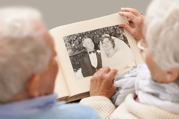 Úgy emlékszem, mintha tegnap lett volna. Egy idős párról, akik az esküvői albumukat lapozzák.. — Stock Fotó
