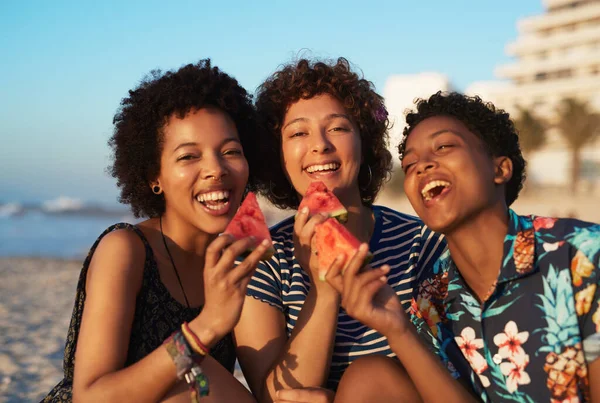 Paylaşmak, gülümsemelerimiz de dahil olmak üzere önemsemektir. Gün boyunca sahilde karpuz yiyen üç çekici genç kadının portresi.. — Stok fotoğraf