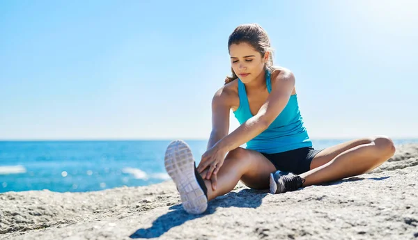 Seja uma mulher forte, por dentro e por fora. Tiro de uma jovem que se estende antes de correr. — Fotografia de Stock