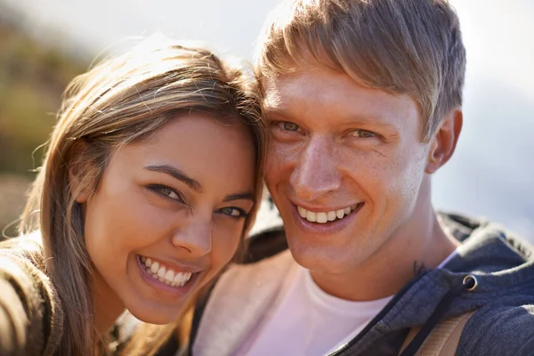 Les encanta salir juntos al aire libre. Retrato de una pareja joven y cariñosa parados afuera juntos bajo el sol. —  Fotos de Stock