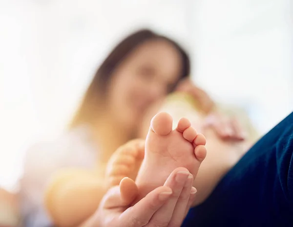 Njut av de små sakerna. Beskuren bild av en mor som rör sin babys fot. — Stockfoto