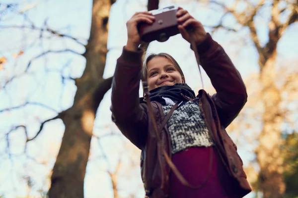 Auf Erkundungstour. Aufnahme eines jungen Mädchens, das ein Selfie mit einer Vintage-Kamera im Freien macht. — Stockfoto