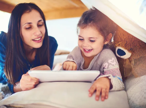 C'est leur façon préférée de s'amuser à l'intérieur. Tournage d'une mère et de sa petite fille à l'aide d'une tablette numérique ensemble à la maison. — Photo