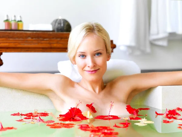 Poder de pétalos de flores. Retrato de atractiva joven en bañera con pétalos de flores rojas. —  Fotos de Stock