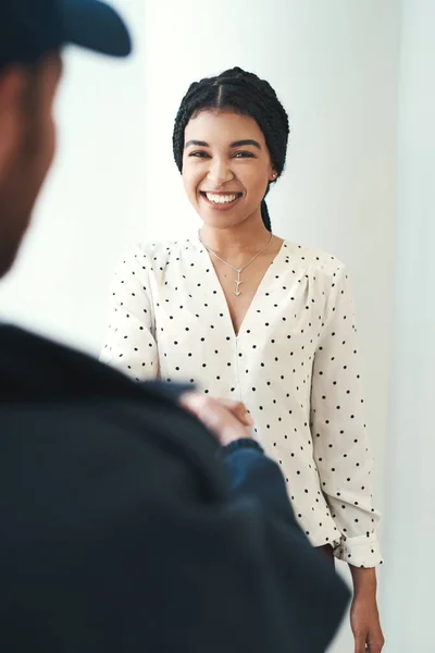 Ótimo serviço sempre vai deixar um sorriso em seu rosto. Tiro de um mensageiro masculino irreconhecível apertando as mãos com uma cliente feminina. — Fotografia de Stock