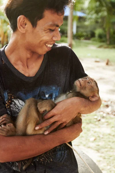 Apenhouder, Thailand. Een Thaise makaak wordt vastgehouden door zijn bewaker. — Stockfoto