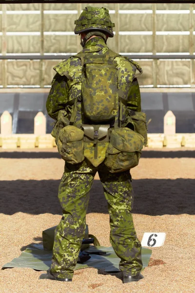Giubbotto pieno di metallo. Retrovisore di un giovane soldato in uniforme con la sua attrezzatura davanti a sé. — Foto Stock