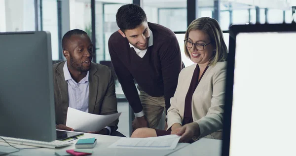 Werken aan gemeenschappelijke doelen. Opgenomen foto van drie zakenmensen die wat papierwerk bespreken in hun kantoor.. — Stockfoto