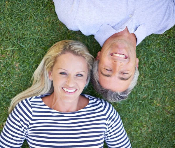 I wouldnt want to be anywhere else. High angle portrait of a mature couple lying in the park. — ストック写真