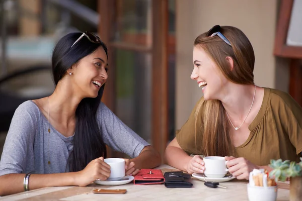 Ponerse al día con los cafés. Dos jóvenes atractivas disfrutando de un café en un bistró. — Foto de Stock