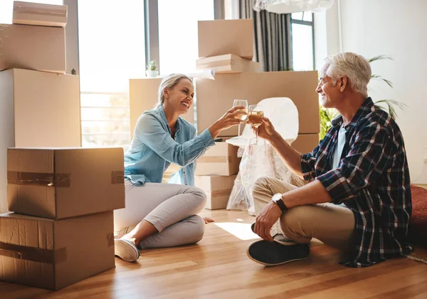 Das Leben läuft auf die Meilensteine hinaus. Aufnahme eines glücklichen, reifen Paares, das am bewegenden Tag mit Wein anstößt. — Stockfoto