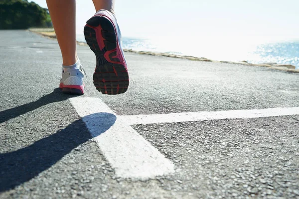 Det är viktigt att ha bra löparskor. Beskuren bild av en atletisk ung kvinna löparskor. — Stockfoto
