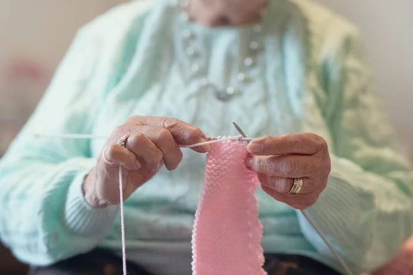 Tricô ajuda a passar o tempo. Tiro de perto de uma mulher idosa irreconhecível tricô. — Fotografia de Stock
