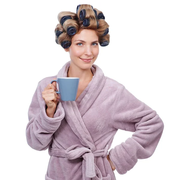 Tutti hanno bisogno di aiuto domattina. Studio shot di una donna con bigodini tra i capelli e indossa un accappatoio bere caffè. — Foto Stock